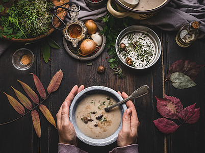 女手碗与秋菜,栗子奶油汤黑暗的乡村厨房桌子背景与落叶,顶部视图季节食物饮食图片