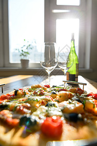家里空酒杯绿色酒瓶新鲜烘焙披萨的图片背景图片