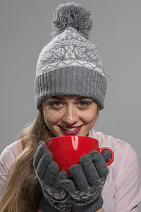 美丽的女人喝热饮料,穿着冬天的衣服计划图片