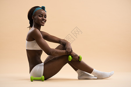 美丽的非洲女人用哑铃拉肌肉图片