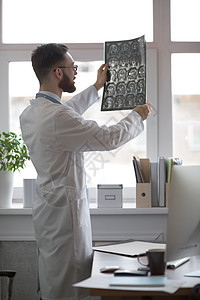 智力男子保健人员的特写照片,白色标签,看脑摄影图像,ct扫描,MRI,临床办公室背景放射科图片