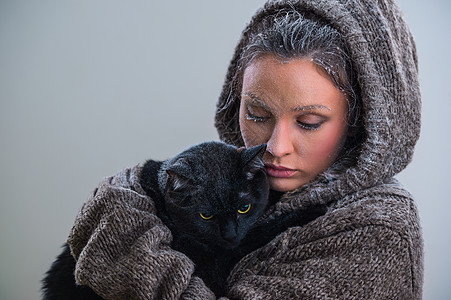 抱着大黑猫的轻善良女人的冬天肖像霜雪他们身上图片