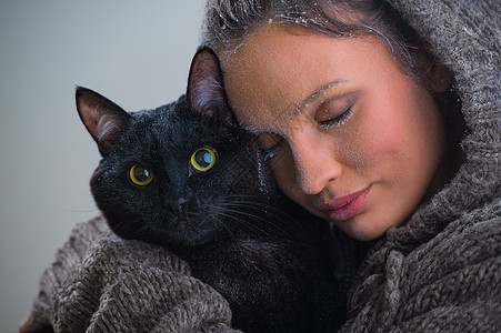 抱着大黑猫的轻善良女人的冬天肖像霜雪他们身上高清图片