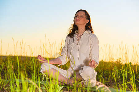 瑜伽女人冥想绿色的草抗太阳图片