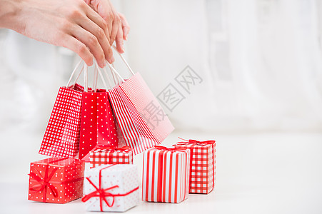 女手红色礼品袋附近的礼品盒购物假日背景图片