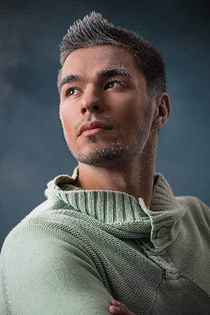 男人冬天的时尚英俊的男人黑发穿着绿色的球衣覆盖着雪冷随意的样子