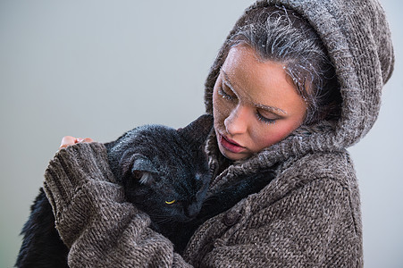 抱着大黑猫的轻善良女人的冬天肖像霜雪他们身上图片