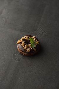 巧克力甜甜圈与薄荷叶暗石背景图片