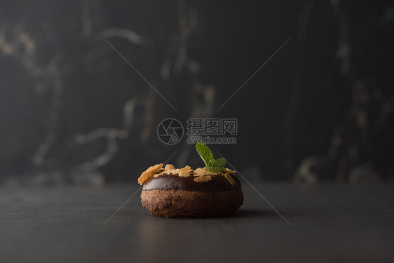 巧克力甜甜圈与薄荷叶暗石背景图片