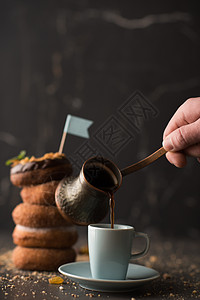 叠甜甜圈,包屑,坚果杯咖啡黑暗的石头背景图片
