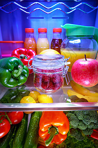 新鲜的覆盆子放璃瓶里,放架子上,打开冰箱健康的食物图片