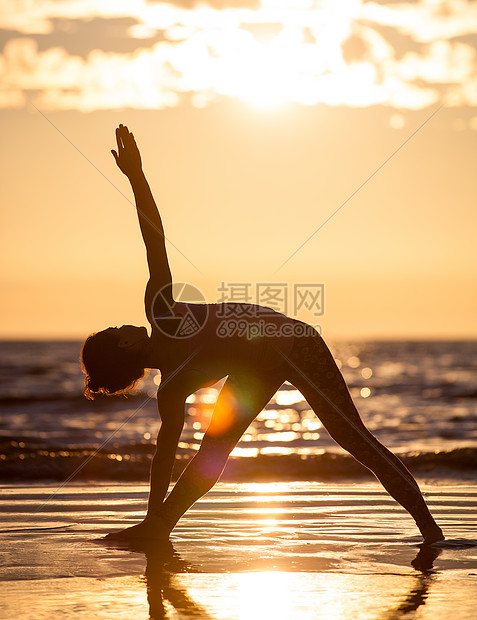 练瑜伽的女人日落时海滩上练瑜伽的女人的剪影图片
