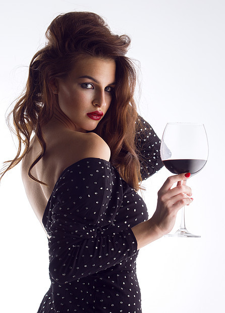 轻漂亮的黑发女人,喝杯红酒带酒杯的漂亮轻女人图片