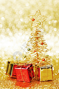 美丽的金色装饰诞树金色闪光背景上的礼物图片