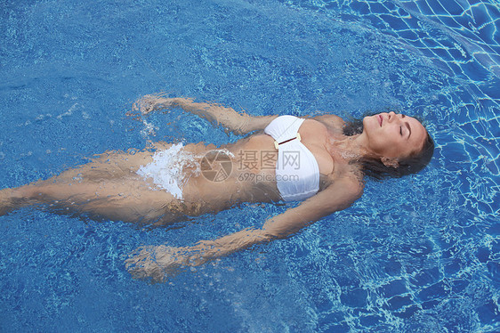 女人漂浮游泳池里近距离观看位漂浮游泳池里的迷人轻女子图片