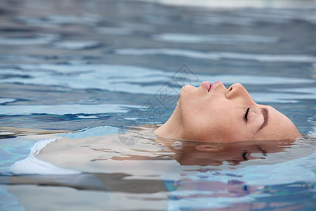 热带海洋放松的女人女人热带海水中漂浮放松图片