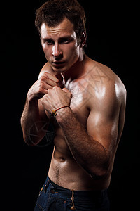 黑色背景下战斗姿态的肌肉男的肖像图片