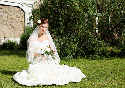 位穿着白色连衣裙花的轻新娘的肖像图片
