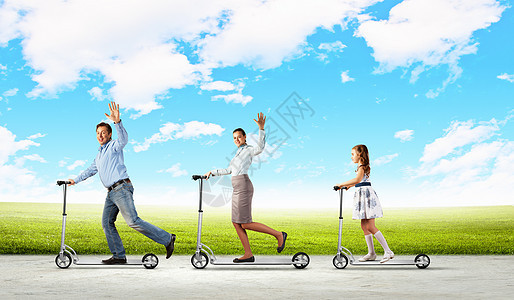 快乐的家庭骑滑板车快乐的轻家庭骑滑板车的形象图片