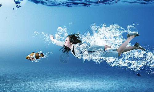 穿着西装的轻女商人水晶蓝色的水里游泳水下的女人图片