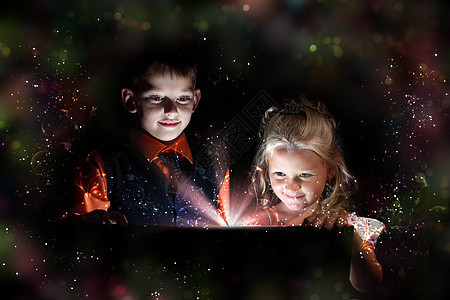 孩子们打开个带灯的魔法礼品盒,周围闪闪发光图片