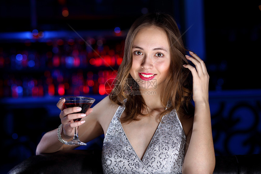 轻的女人穿着晚礼服夜总会喝酒图片