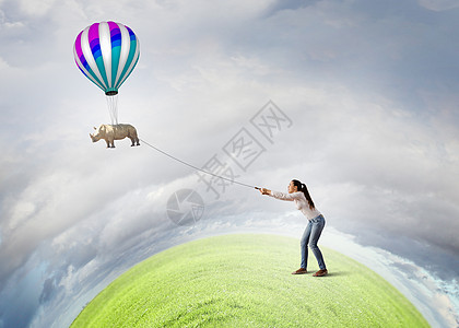 犀牛铅上轻的女人穿着休闲装,犀牛天空中飞翔图片