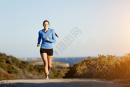 运动跑步者海滩上慢跑锻炼适合女健身模型沿海洋慢跑图片
