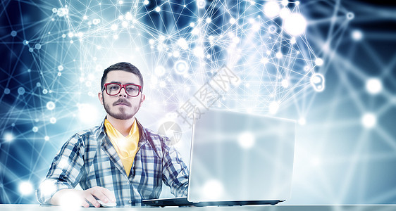 时髦的家伙用笔记本电脑戴着红色眼镜的轻帅哥上网冲浪图片