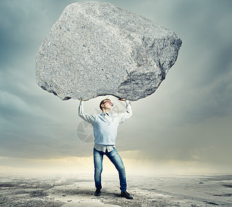 搬石头的家伙轻强壮的男人头顶着巨大的石头图片
