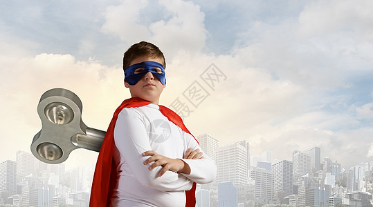 多动的超级孩子小超级活跃的男孩,背上钥匙,穿着超级英雄的服装图片