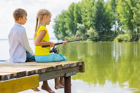 夏季休闲两个孩子坐岸边钓鱼的后视镜图片