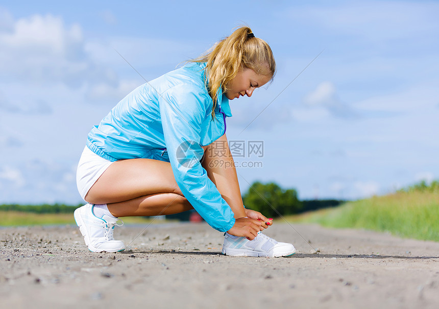 户外跑步轻健康的女孩系运动鞋的鞋带图片