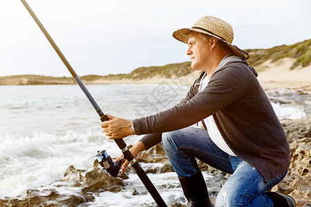 户外钓鱼渔夫的照片渔夫用鱼竿钓鱼的照片背景
