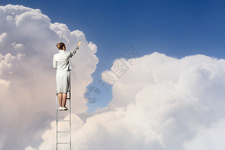 女商人站梯子上女商人站梯子上,多云的背景下眺望远方图片