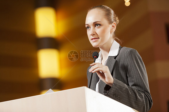 女商人站舞台上为观众报道演讲者舞台上图片