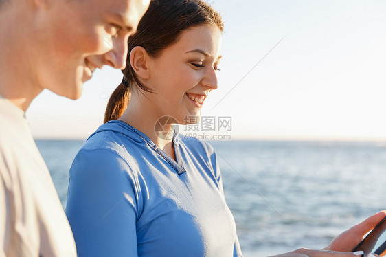 智能手机的轻夫妇户外两个轻人户外运动时穿着智能手机图片