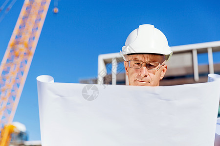 建筑工地的工程师建设者工程师建筑工人施工场景穿着带蓝图的安全背心图片