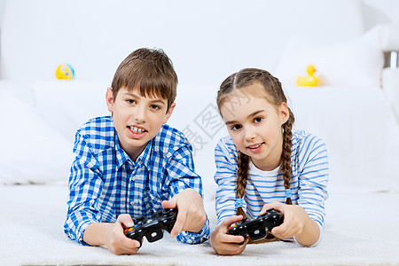 孩子们玩游戏控制台情绪激动的孩子躺地上,操纵杆上玩游戏图片