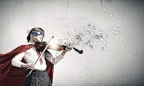超灵巧的小提琴演奏可爱的学校女孩穿着超级英雄服装拉小提琴图片