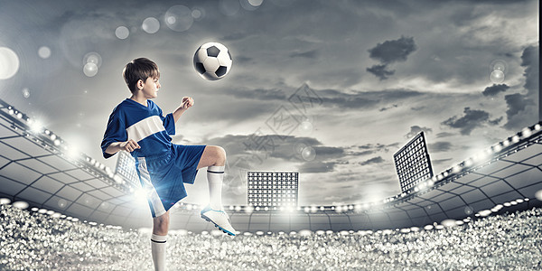 小足球馅饼穿着蓝色制服的男孩足球场踢球图片