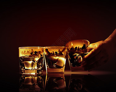 三杯威士忌手着三杯威士忌中的杯加冰派插图图片