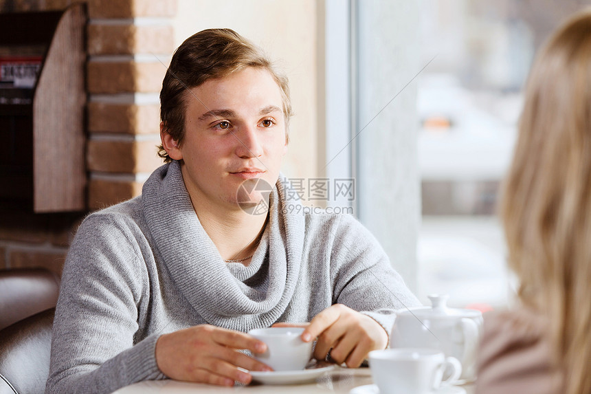 情侣约会轻人女孩坐咖啡馆的桌子上图片