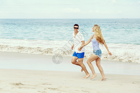 浪漫的轻夫妇海滩上浪漫的轻夫妇海滩上沿着海岸奔跑图片