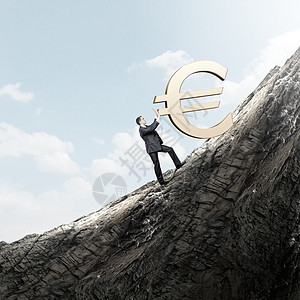 欧元轻的商人滚上山的大欧元标志图片