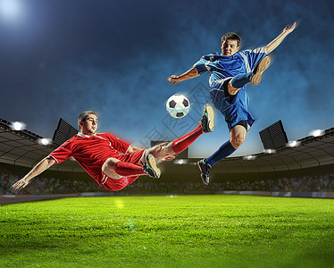 两名足球运动员击球两名足球运动员体育场跳以击球图片