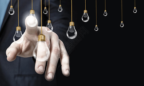观念创造力的特写商人用手指触摸虚拟灯泡图片