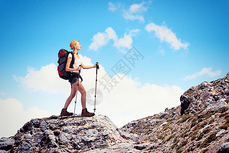 轻的女人登山者站山顶上的漂亮山顶上图片