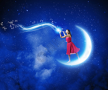 女人玩Fife穿着红色连衣裙的轻女人站月亮上玩Fife图片