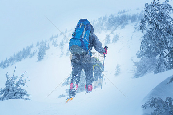 冬天山上的徒步旅行者图片